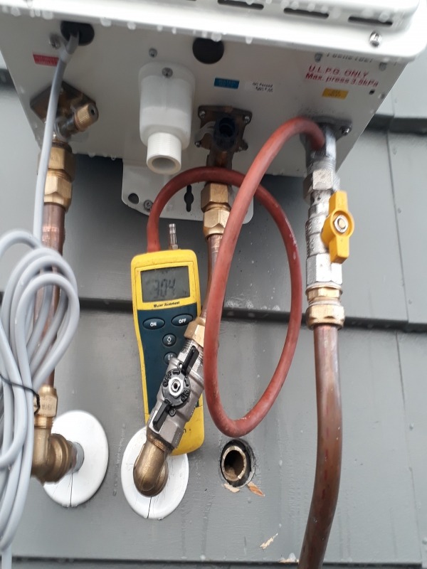 Gasfitter pressure testing a continuous flow water heater in Auckland