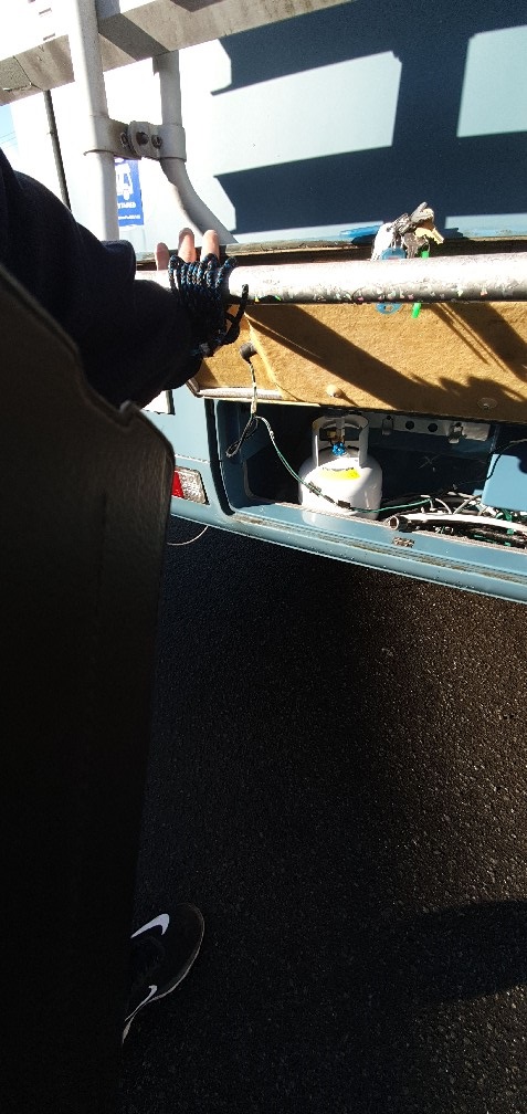 Gasfitter servicing an LPG compartment on a caravan