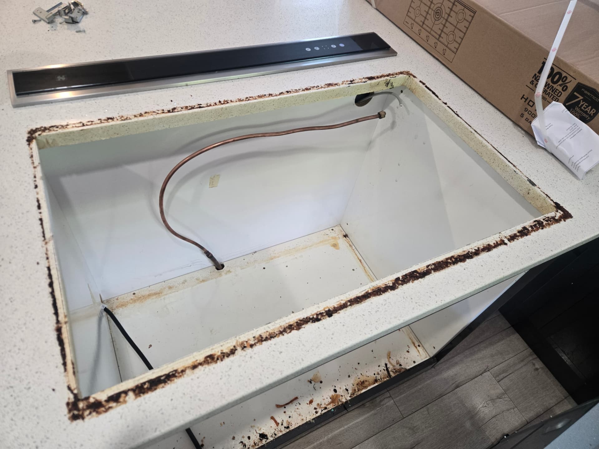 Existing gas connection visible below the cleared hob opening