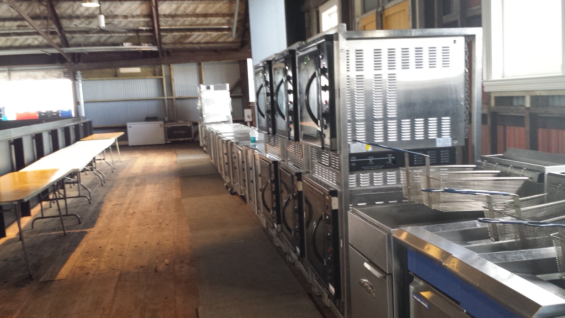 Row of commercial gas fryers and ovens on a large fit-out