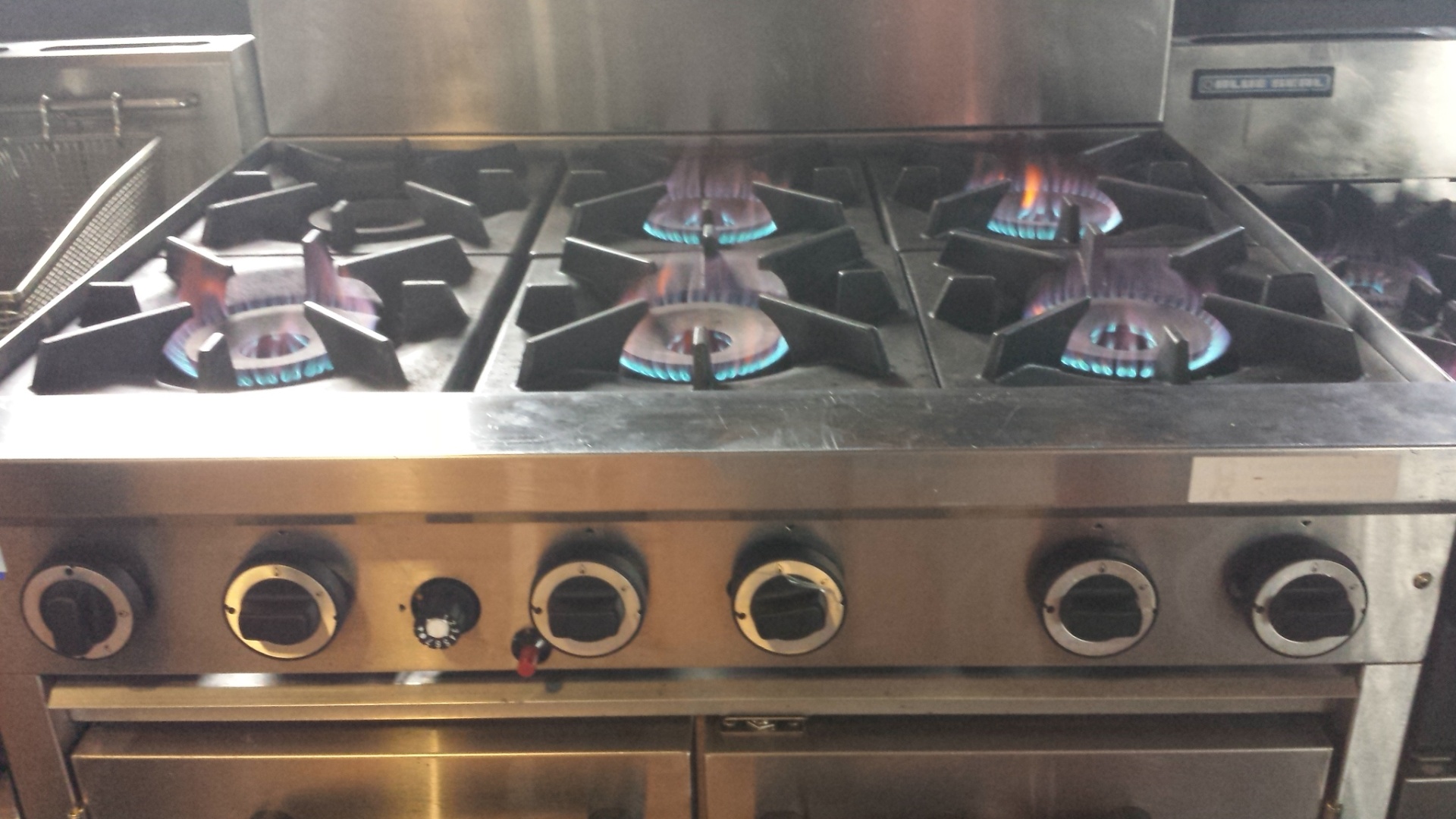 Commercial 6-burner gas range firing on all burners